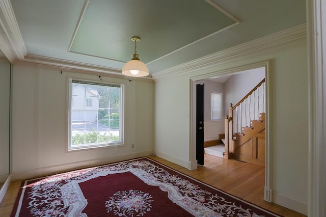 1313 NW 12th St, Blue Springs, MO 64015 - empty room with ornamental molding, a tray ceiling, light wood-type flooring, baseboards, and stairs