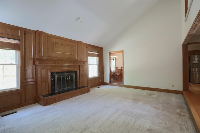 1313 NW 12th St, Blue Springs, MO 64015 - unfurnished living room featuring high vaulted ceiling, a chandelier, light carpet, a fireplace, and baseboards