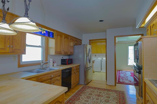 1313 NW 12th St, Blue Springs, MO 64015 - kitchen featuring black appliances, washer and clothes dryer, healthy amount of natural light, and light countertops