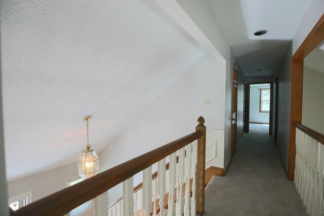 1313 NW 12th St, Blue Springs, MO 64015 - hallway featuring carpet flooring, vaulted ceiling, an upstairs landing, and baseboards