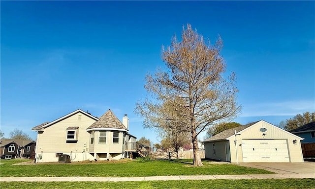 exterior space with fence, a garage, a lawn, and a chimney