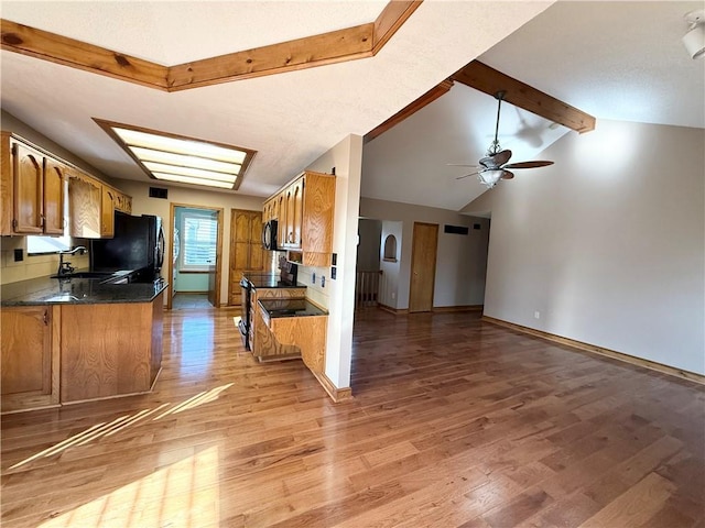 kitchen with light wood-type flooring, brown cabinets, a sink, and a ceiling fan