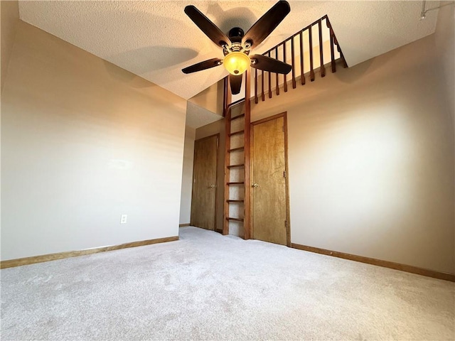 empty room with baseboards, a ceiling fan, carpet flooring, and a textured ceiling