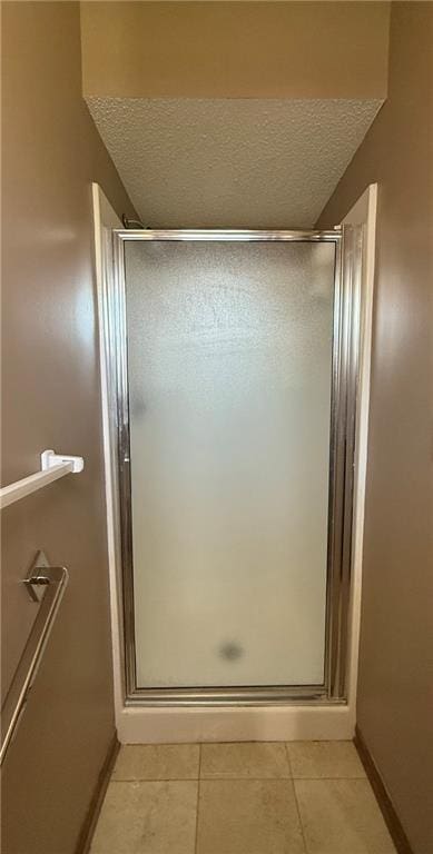 bathroom featuring a shower stall, tile patterned floors, and a textured ceiling