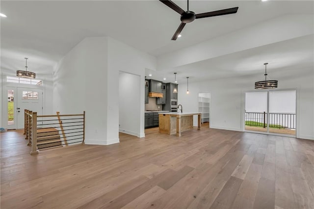502 Seventh St, Smithville, MO 64089 - unfurnished living room featuring light wood-style floors, baseboards, a ceiling fan, recessed lighting, and a sink