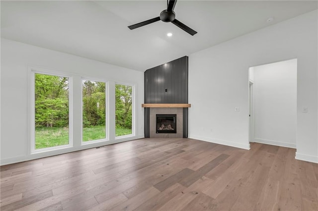 502 Seventh St, Smithville, MO 64089 - unfurnished living room with a ceiling fan, light wood-type flooring, a large fireplace, lofted ceiling, and baseboards