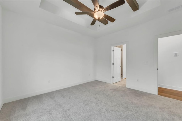 502 Seventh St, Smithville, MO 64089 - unfurnished room with a tray ceiling, light colored carpet, a ceiling fan, and baseboards