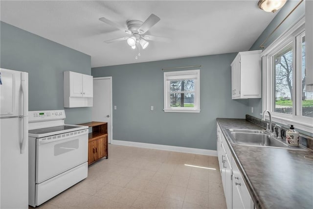 kitchen featuring baseboards, white appliances, white cabinets, ceiling fan, and a sink