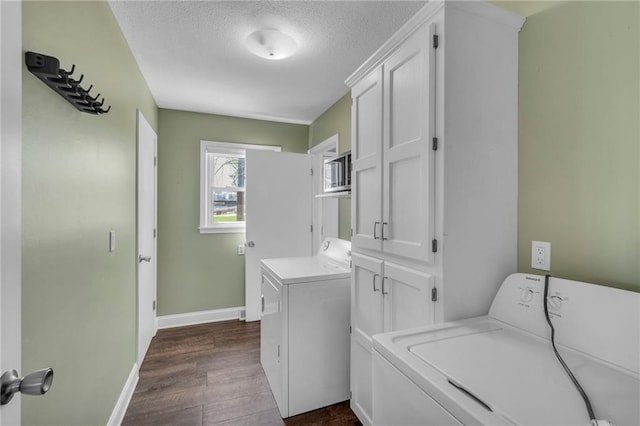 laundry room featuring baseboards, separate washer and dryer, dark wood-style flooring, a textured ceiling, and cabinet space