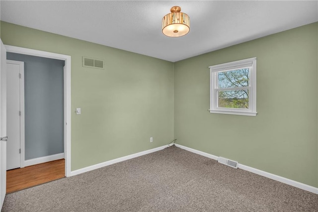unfurnished room with visible vents, baseboards, and carpet flooring