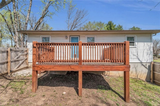rear view of property featuring a wooden deck and fence