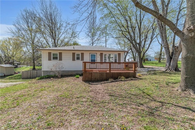 view of front of house with a wooden deck and a front lawn