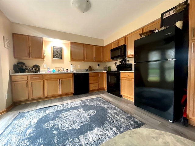 8200 Chas Cir, Pleasant Valley, MO 64068 - kitchen featuring baseboards, light countertops, black appliances, and light wood finished floors
