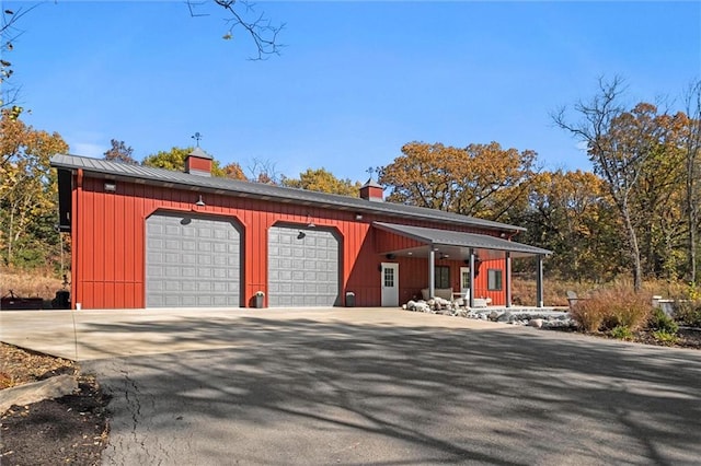 33345 W 95th St, De Soto, KS 66018 - view of front of property with a chimney, a detached garage, a porch, and board and batten siding