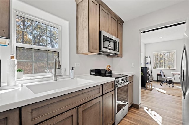 33345 W 95th St, De Soto, KS 66018 - kitchen featuring appliances with stainless steel finishes, a sink, light countertops, and light wood finished floors