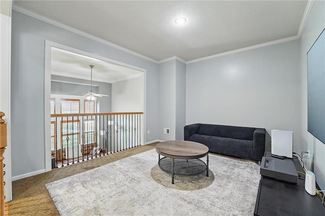 sitting room featuring carpet flooring, a ceiling fan, baseboards, and ornamental molding