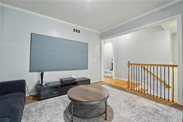living room featuring visible vents, baseboards, crown molding, and stairway