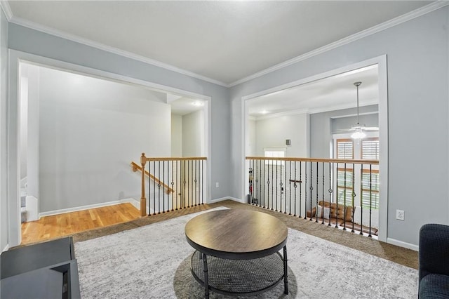sitting room with baseboards, ornamental molding, wood finished floors, and an upstairs landing