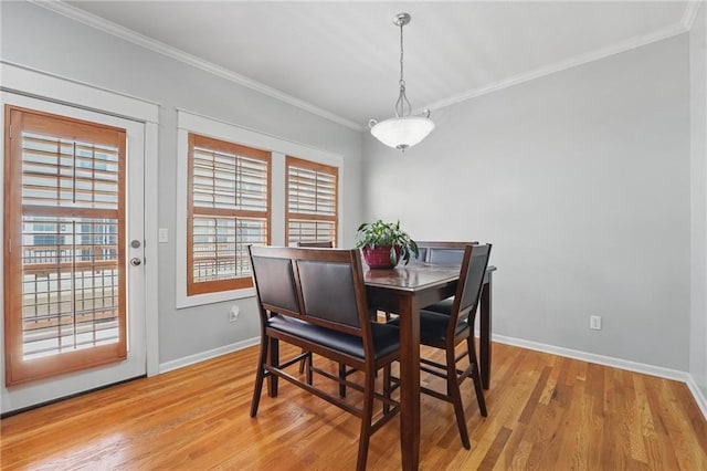dining area featuring baseboards, ornamental molding, and light wood finished floors