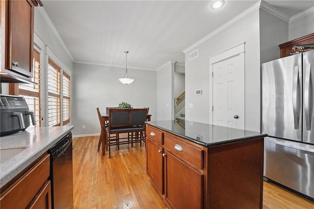 kitchen with light wood finished floors, freestanding refrigerator, a kitchen island, visible vents, and dishwashing machine