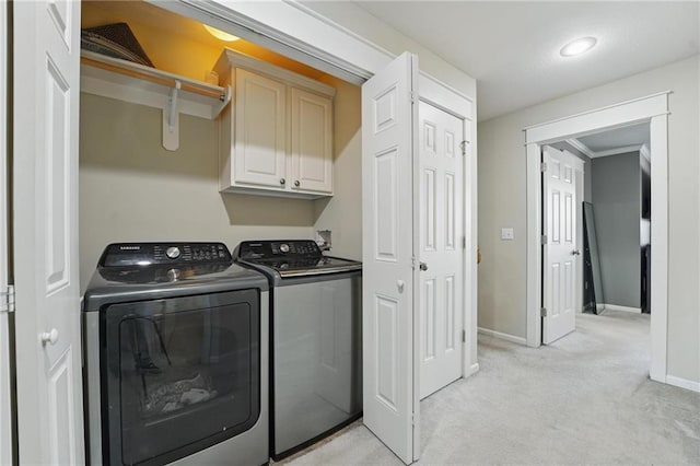 laundry area with baseboards, washing machine and dryer, cabinet space, and light colored carpet