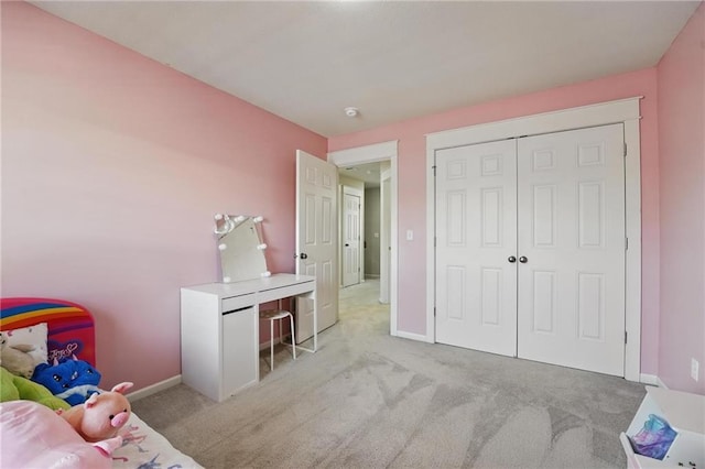 carpeted bedroom featuring baseboards and a closet