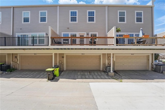 back of property with central AC, driveway, and a garage