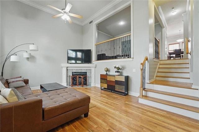 living area with crown molding, ceiling fan, wood finished floors, and visible vents