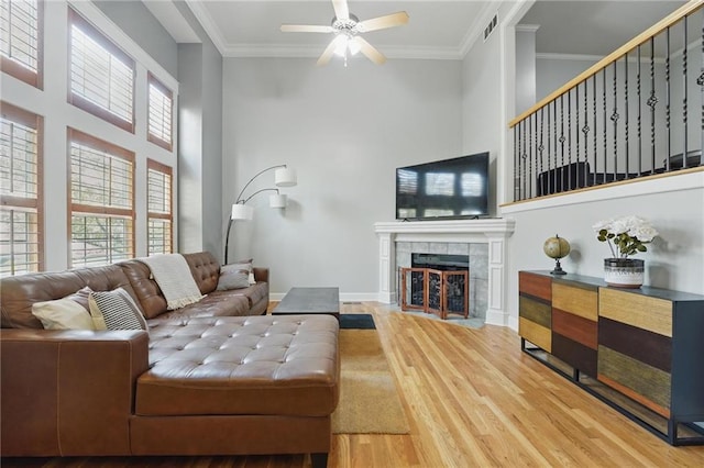 living area featuring ceiling fan, visible vents, a healthy amount of sunlight, and wood finished floors