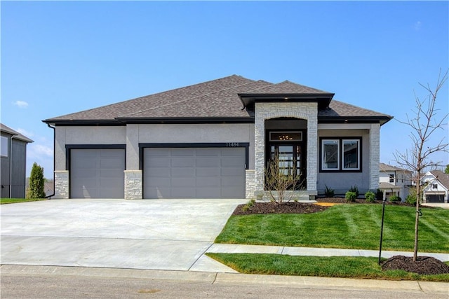 9027 Freedom Cir, Lenexa, KS 66227 - prairie-style house featuring an attached garage, driveway, a front yard, and stone siding