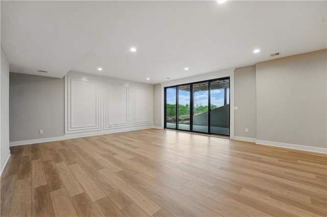spare room with light wood finished floors, baseboards, and recessed lighting