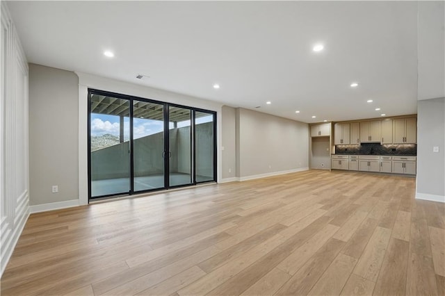 unfurnished living room featuring light wood-style floors, baseboards, and recessed lighting