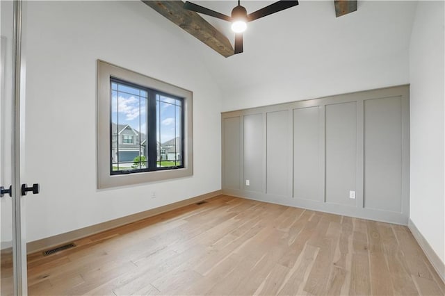 unfurnished bedroom with light wood finished floors, a decorative wall, and ceiling fan