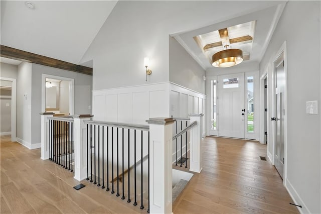 hallway featuring an upstairs landing, light wood-type flooring, and baseboards