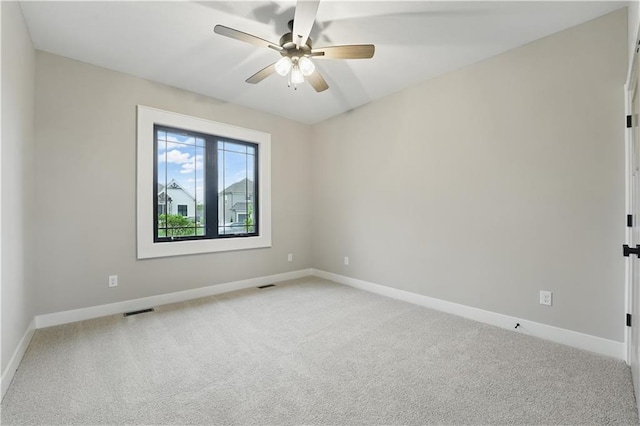 unfurnished room featuring light colored carpet, baseboards, and a ceiling fan