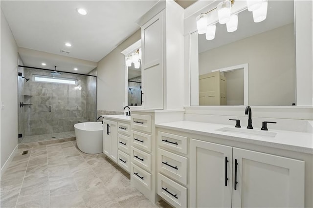 full bath featuring a shower stall, double vanity, recessed lighting, and a freestanding bath