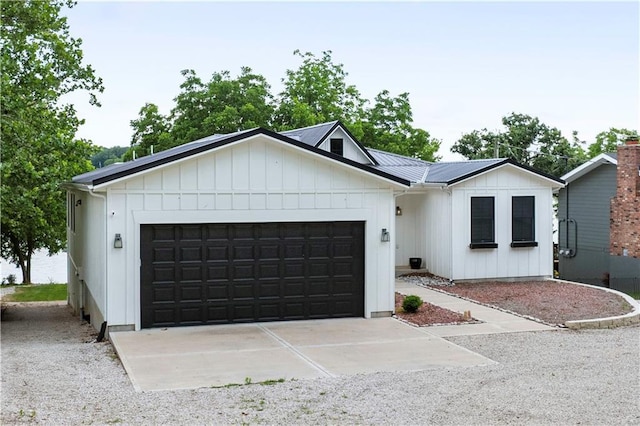 38 Lakeview Ln, Linn Valley, KS 66040 - view of front of property featuring a garage, board and batten siding, concrete driveway, and a metal roof