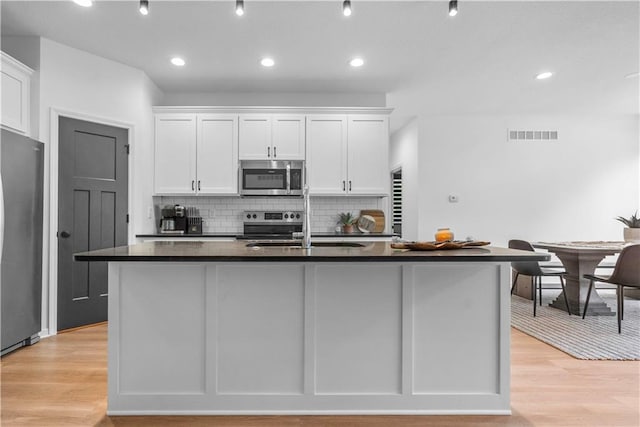 38 Lakeview Ln, Linn Valley, KS 66040 - kitchen with stainless steel appliances, dark countertops, white cabinets, decorative backsplash, and recessed lighting