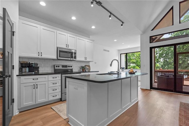 38 Lakeview Ln, Linn Valley, KS 66040 - kitchen with appliances with stainless steel finishes, dark countertops, light wood-style flooring, white cabinets, and backsplash
