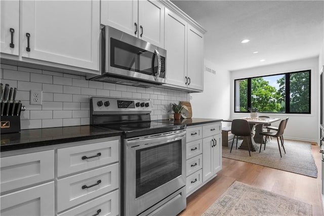 38 Lakeview Ln, Linn Valley, KS 66040 - kitchen with stainless steel appliances, tasteful backsplash, white cabinetry, light wood finished floors, and recessed lighting