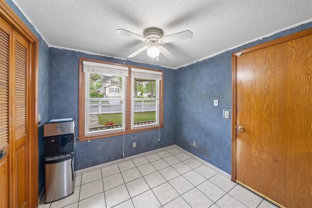 4401 N Holmes St, Kansas City, MO 64116 - spare room featuring light tile patterned flooring, a textured ceiling, baseboards, and ceiling fan