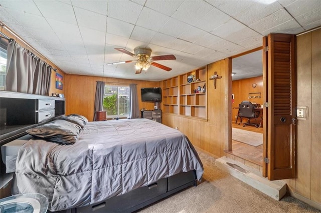4401 N Holmes St, Kansas City, MO 64116 - carpeted bedroom with a ceiling fan and wooden walls