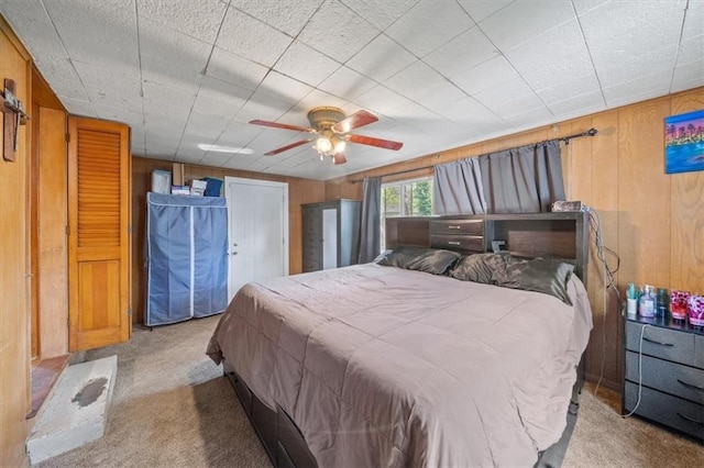 4401 N Holmes St, Kansas City, MO 64116 - carpeted bedroom featuring ceiling fan and wood walls