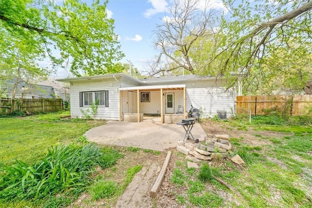 4401 N Holmes St, Kansas City, MO 64116 - back of property featuring fence private yard, a lawn, and a patio