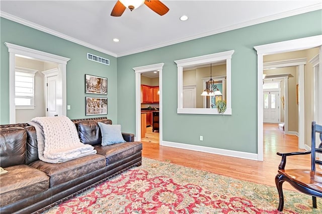3205 SW Rockbridge Dr, Lees Summit, MO 64081 - living room with crown molding, a ceiling fan, visible vents, and wood finished floors