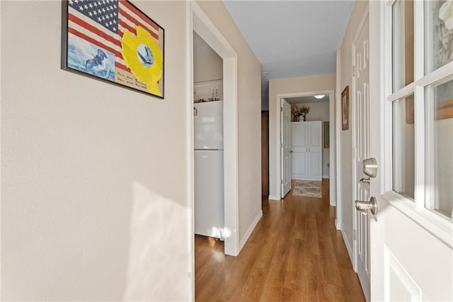 hallway featuring wood finished floors and baseboards