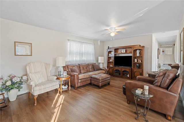 living area with wood finished floors and ceiling fan