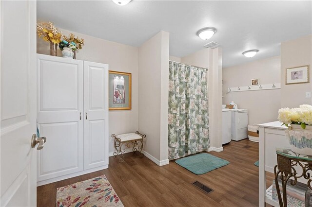 full bathroom featuring separate washer and dryer, wood finished floors, visible vents, and a shower with curtain