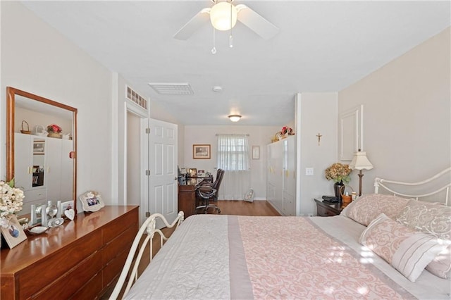 bedroom with visible vents, a ceiling fan, and wood finished floors
