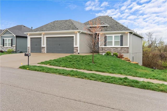 craftsman-style home with an attached garage, concrete driveway, a front yard, and stone siding